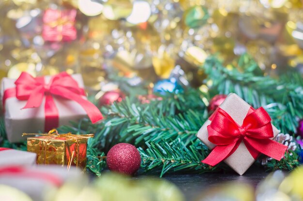 Cerca de la caja de regalo de artesanía con cinta roja en la mesa de madera para la decoración de Navidad o año nuevo