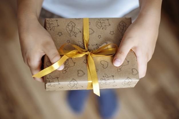 Foto cerca de una caja de regalo en manos de un niño