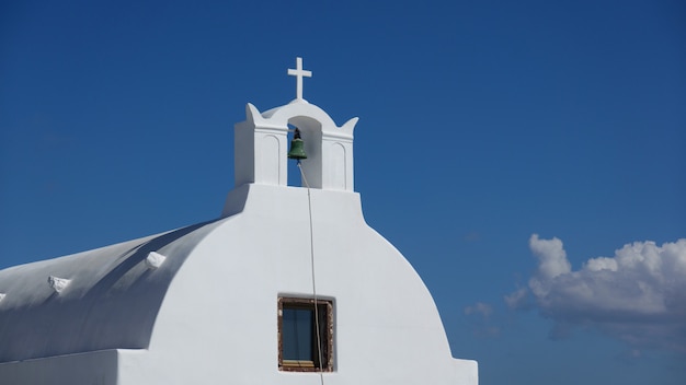 Cerca de la campana, iglesia blanca en Oia Santorini, Grecia.