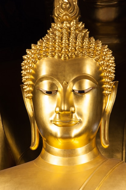 Cerca de la cara de la estatua budista de oro