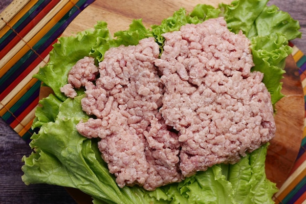 Cerca de carne picada en una tabla de cortar en la mesa