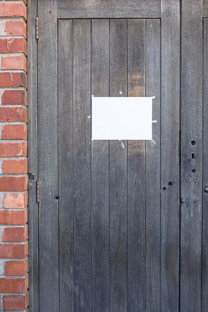 Cerca de un cartel en blanco colgado en una puerta de madera