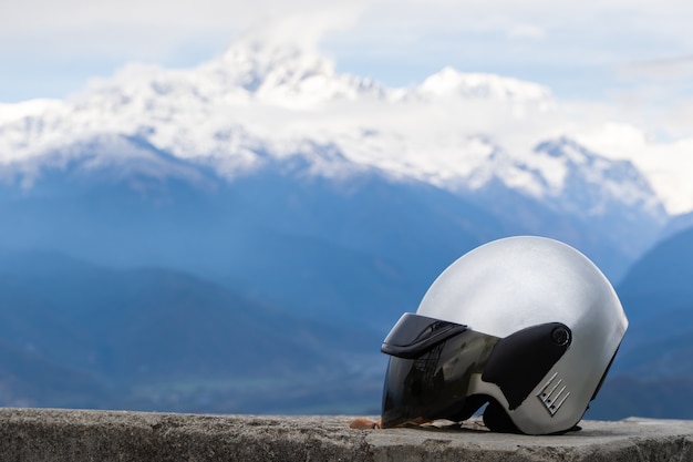 Cerca del casco de la motocicleta con cordillera en el fondo. Free riding, viajar en concepto de moto. Foto de stock.