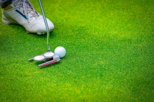 De cerca el club de golf y la pelota de golfista poniéndolo