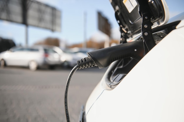 Cerca del coche eléctrico que se está cargando