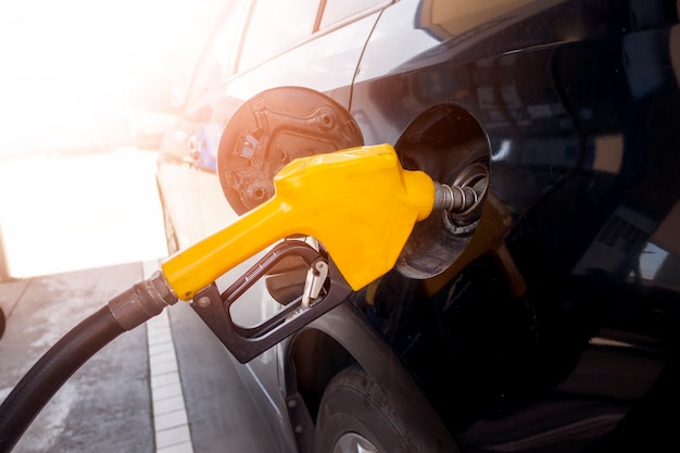 Cerca del coche está rellenando combustible combustible en la estación de servicio