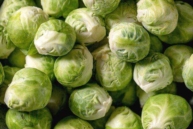 Cerca de coles de Bruselas orgánicas crudas peladas mini repollo. Verduras alimentación saludable. Vista superior, fondo de alimentos