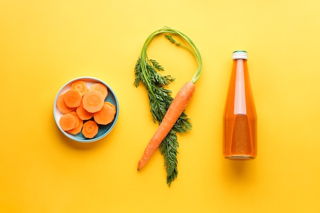 De cerca la composición con rodajas, jugo y zanahorias frescas maduras