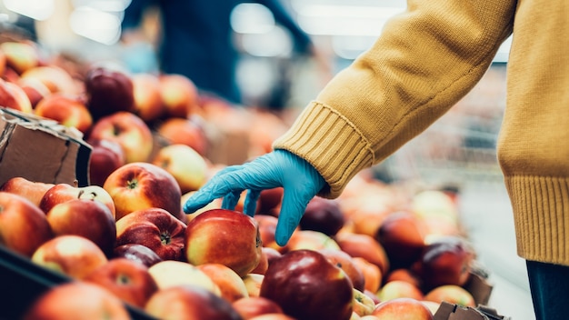 De cerca. El comprador está recogiendo manzanas en la tienda.