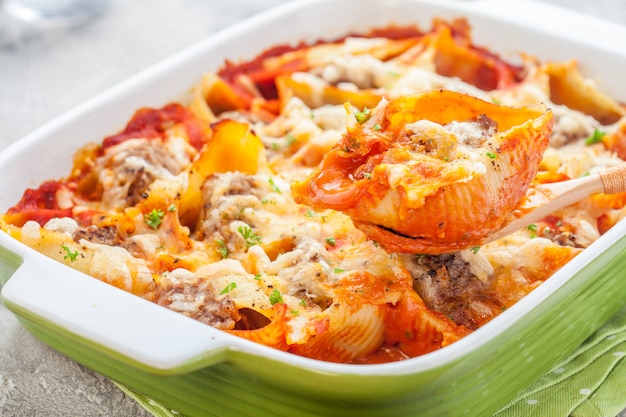 Cerca de conchas de pasta rellena al horno