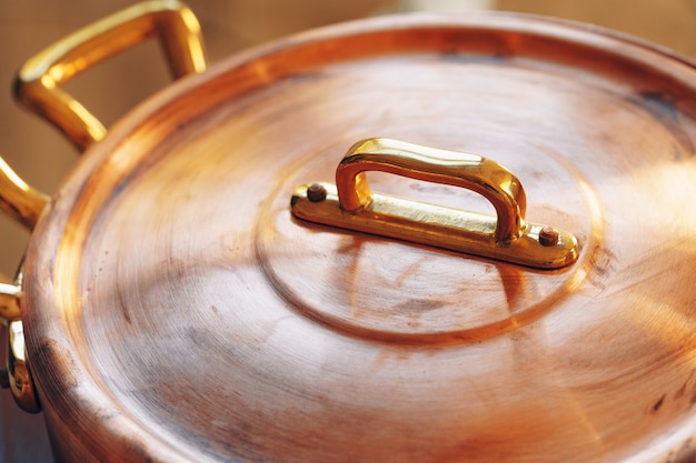 Cerca de un conjunto de utensilios de cocina de cobre