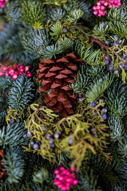 Cerca de la corona de Navidad decorada con piñas y bayas.