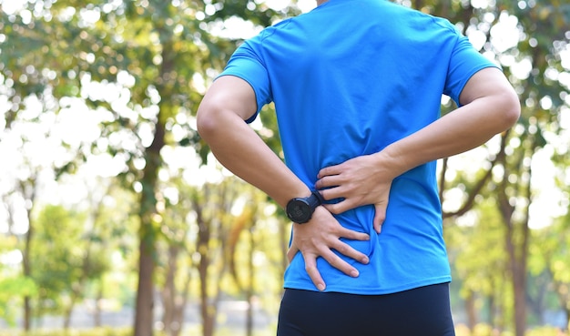 Cerca de corredor joven tiene dolor o lesión muscular y articular durante el ejercicio al aire libre