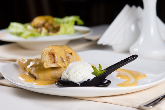 Cerca de crepes de postre gourmet con bola de helado servido en la mesa del restaurante