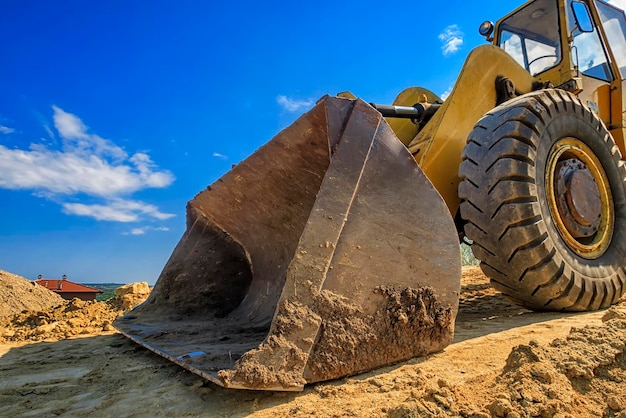 Cerca de un cubo grande de una excavadora amarilla