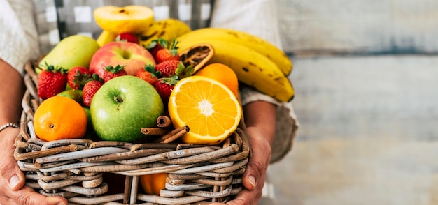 Cerca del cubo de sabrosas frutas frescas sostenido por manos de mujer y copie el fondo del espacio - comida de temporada colorida para el concepto de estilo de vida saludable de dieta