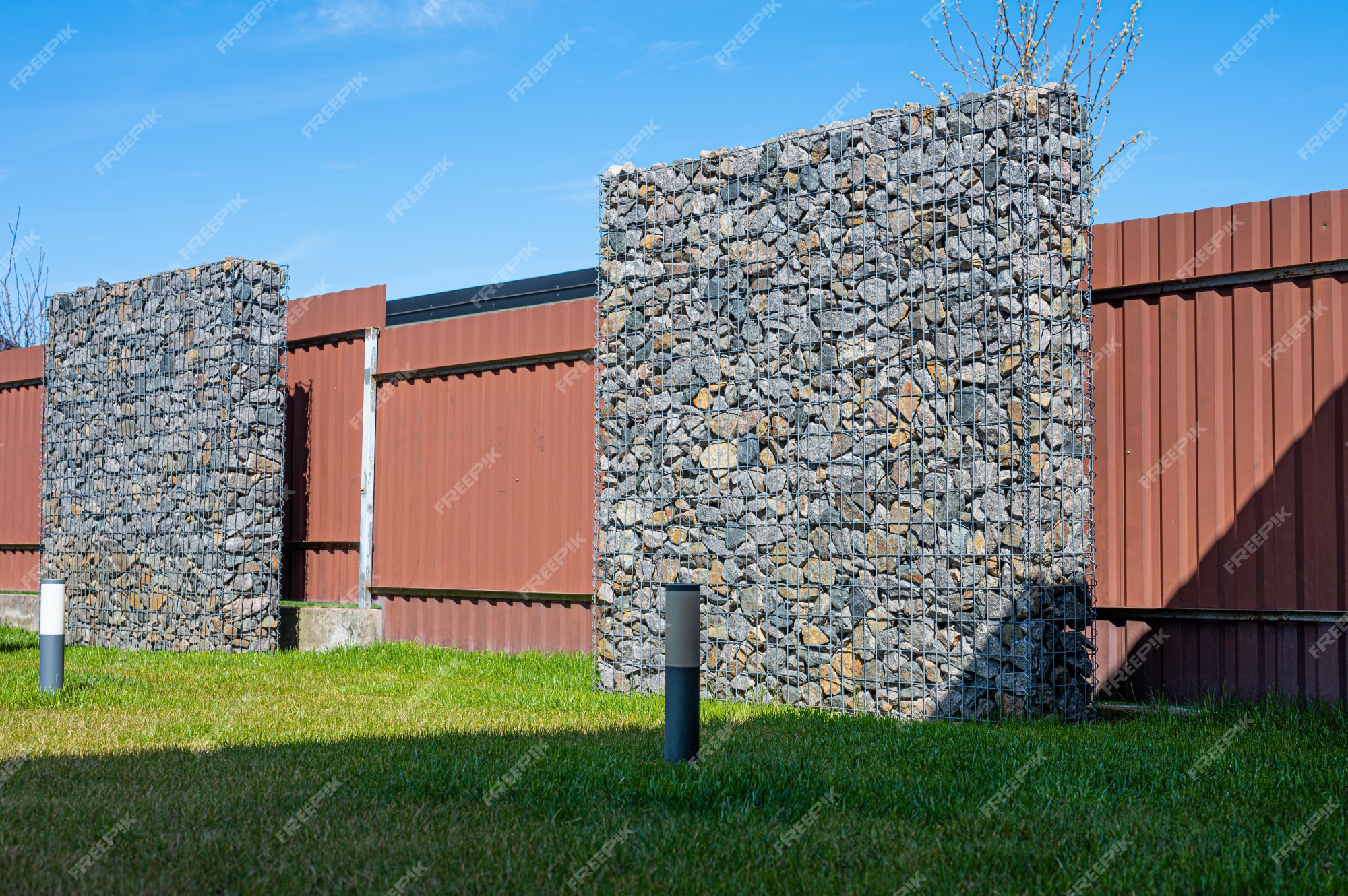 Cerca decorativa de pedra a granel na grade fundo texturizado de uma parede  de pedra com rede de ferro parede de pedra em armação de arame gabião  preenchido com calcário