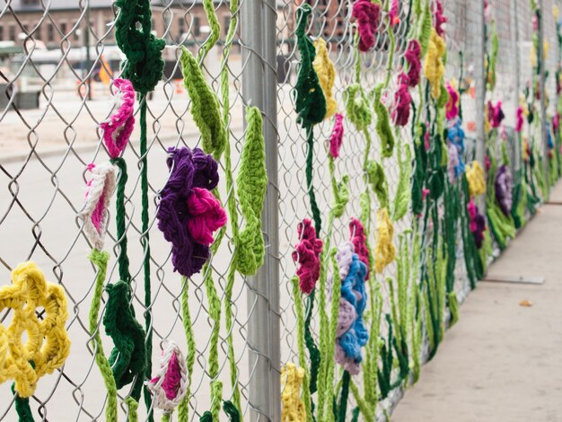 Cerca de construção coberta com criaturas de jardim de crochê, como insetos e flores, pela Ladies Fancywork Society. Canteiro de obras da Union Station em Denver, Colorado.