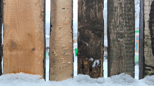 Foto cerca de madeira na neve fundo de inverno textura de madeira