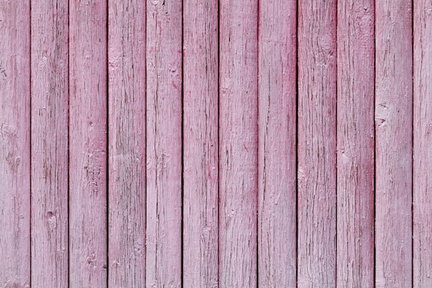 Cerca de madeira velha de textura com tinta rosa descascada