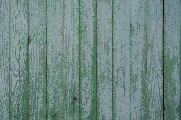 cerca de madeira velha pintada com tinta verde rachada do tempo