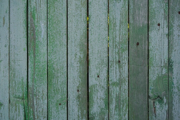 cerca de madeira velha pintada com tinta verde rachada do tempo