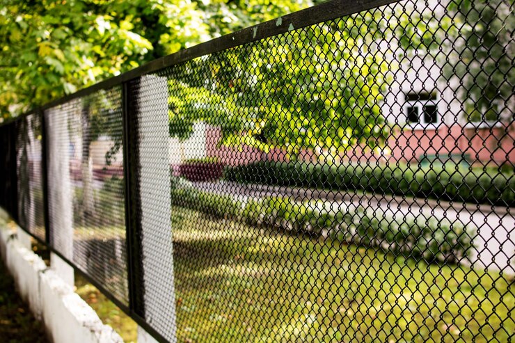 Cerca de malha de metal no fundo do jardim verde