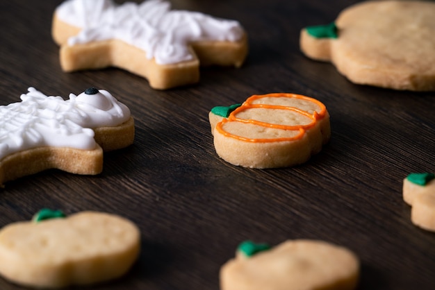 Cerca de la decoración de lindas galletas de jengibre de calabaza de Halloween con una bolsa de cobertura de glaseado glaseado.