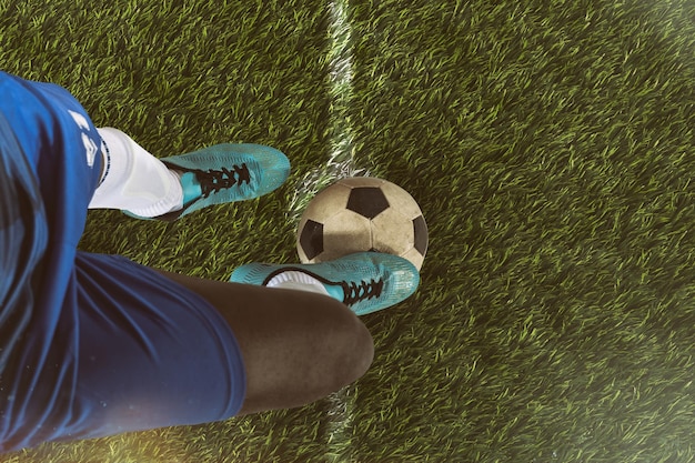 Cerca de un delantero de fútbol listo para patear la pelota en el estadio