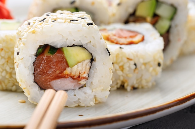 Cerca de delicioso rollo de sushi japonés en placa