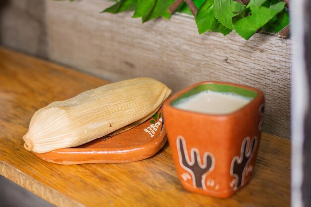 Cerca de un delicioso tamal tradicional mexicano con atole