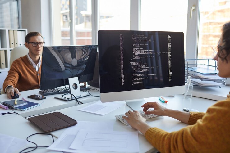 Foto cerca del desarrollador de ti escribiendo código en la pantalla de la computadora mientras colabora en el proyecto con el equipo de diseñadores de software, copie el espacio