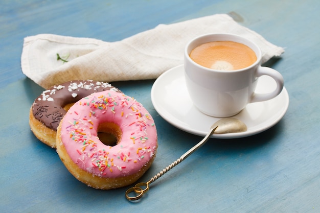 Cerca de donas frescas junto a la taza de café