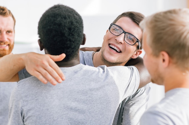 Foto de cerca. dos amigos estudiantes felices abrazándose