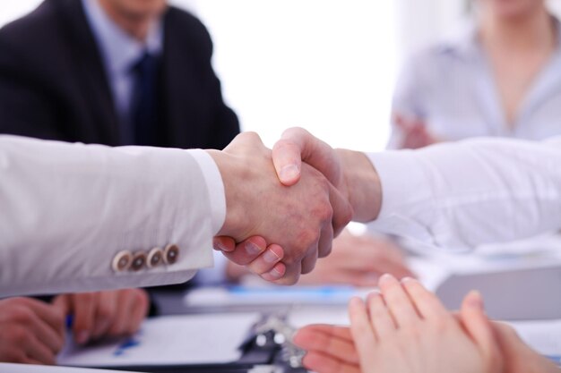 Foto cerca de dos hombres de negocios dándose la mano terminando la reunión