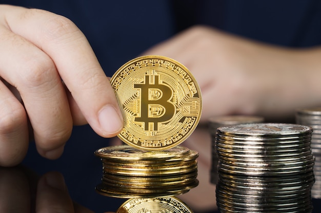 Cerca de la empresaria sosteniendo algunos trozos de token Bitcoin dorado, Bitcoin es una de las criptomonedas populares