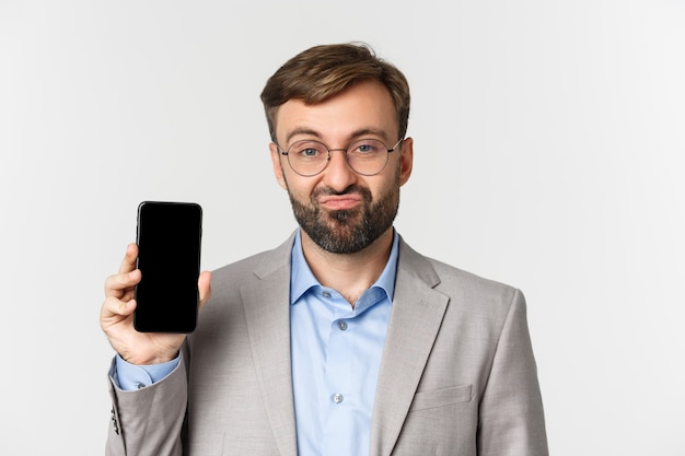 Cerca del empresario escéptico en gafas y traje gris