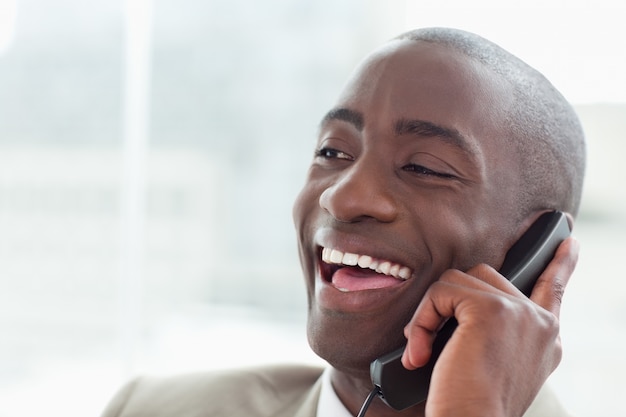 Cerca de un empresario riendo en el teléfono