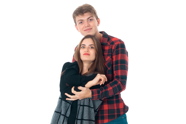 Foto cerca de la encantadora pareja joven con estilo en el amor divirtiéndose en el estudio aislado sobre fondo blanco.