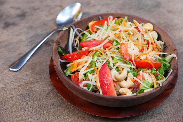 Cerca de ensalada de verduras frescas en un recipiente sobre la mesa.