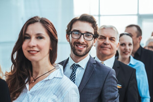 Foto de cerca. un equipo de empleados experimentados haciendo cola. el concepto de trabajo en equipo