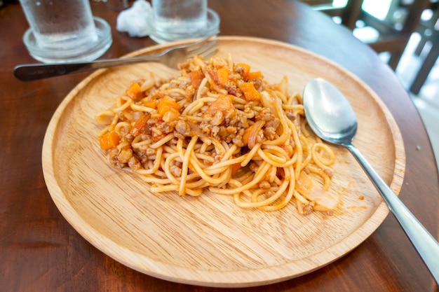 Cerca de espaguetis en plato de madera