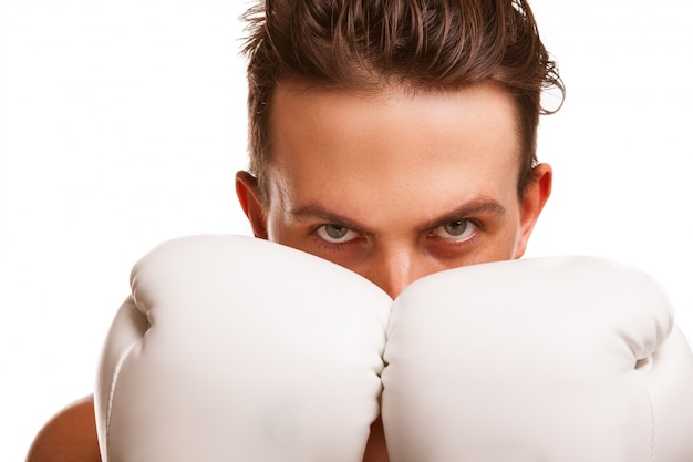 Foto cerca de un feroz boxeador sosteniendo sus puños en guantes de boxeo