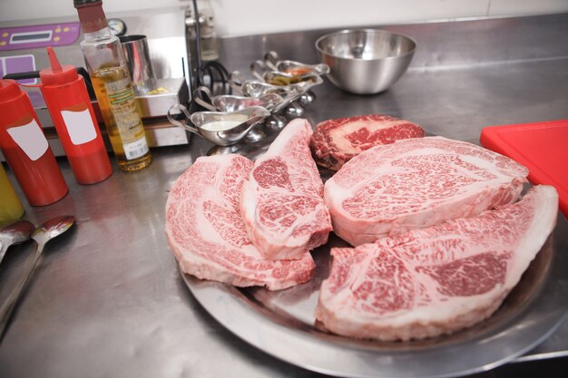 Cerca de filetes de ternera de mármol en un plato en la cocina del restaurante