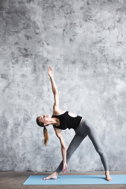 Cerca de fitness yoga mujer en mat en el gimnasio