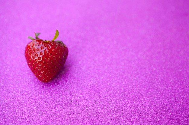 Cerca de fresa fresca sobre fondo rosa brillante, espacio de copia