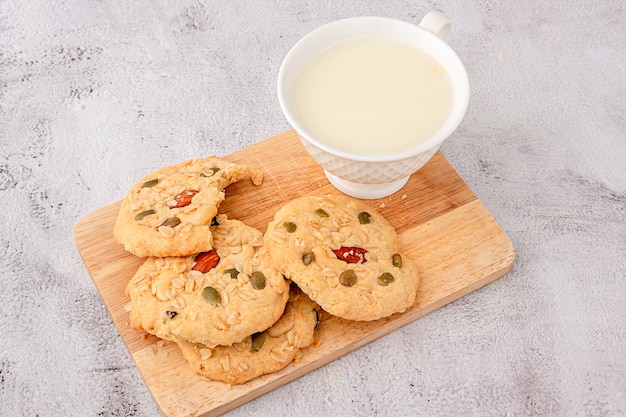 Cerca de las galletas de cereales se apilan en la tabla de cortar, galletas cubiertas con almendras, pasas, semillas de girasol, semillas de calabaza, cereales integrales.