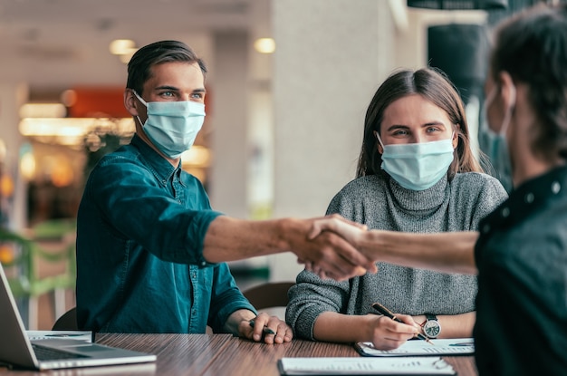 De cerca. gente de negocios dándose la mano sobre un escritorio de oficina.