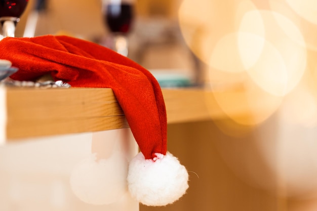 Cerca de gorro de Papá Noel colgando de la mesa de madera