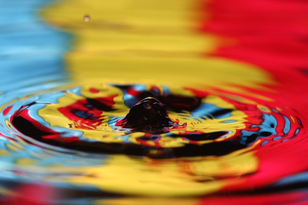 Foto cerca de una gota de agua que cae e impacta con un cuerpo de agua